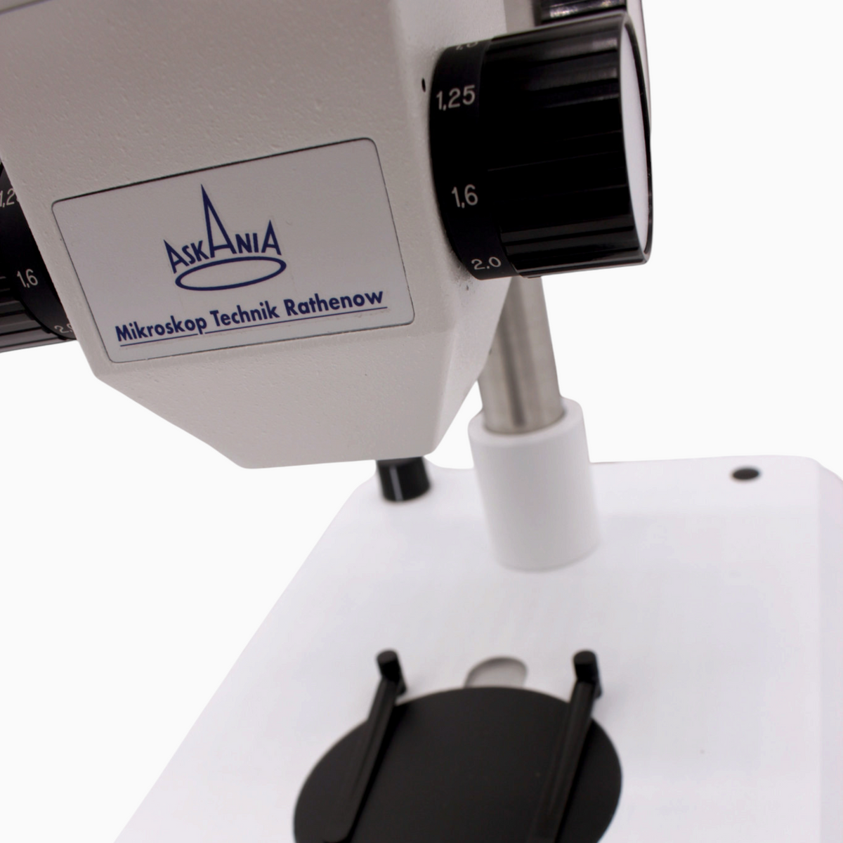 ASKANIA Mikroskoptechnik GSZ Stereo-Zoom-Mikroskop mit weißem Stativfuß, schwarzer Einlegeplatte und Präparateklemmen