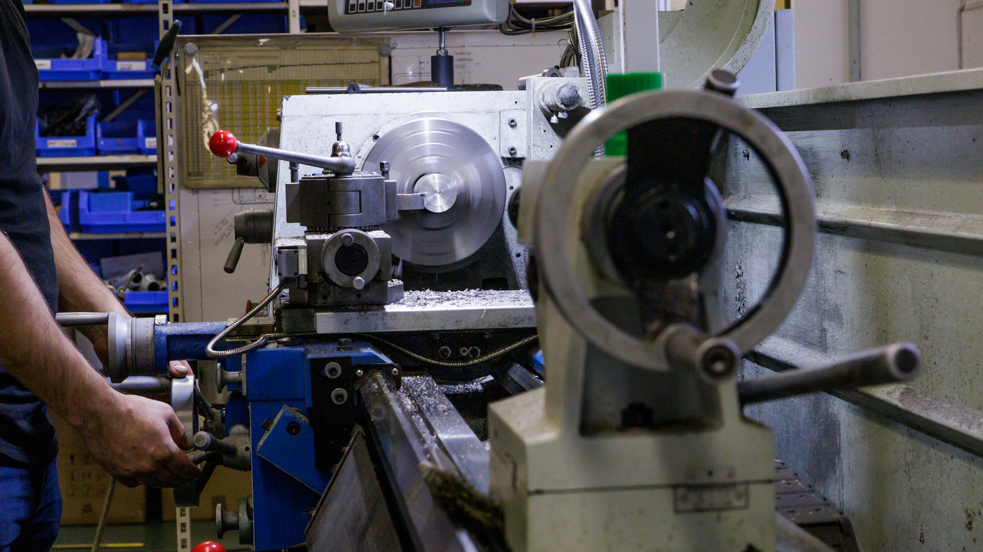 Mitarbeiter steht an einer Drehfräse 
