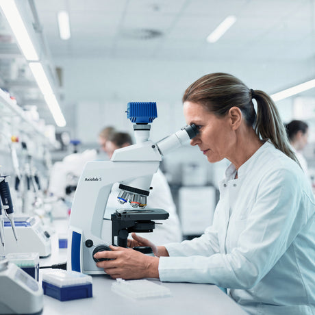 Wissenschaftlerin bei der Arbeit mit einem Askania Mikroskop und Immersol W 2010 Immersionsmittel im Labor
