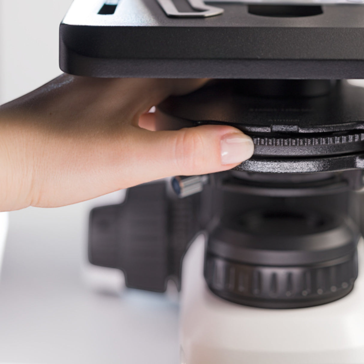 ASKANIA Mikroskoptechnik ZEISS Primostar 3 Mikroskop mit Hand bei der Einstellung des Phasenkontrast-Kondensors