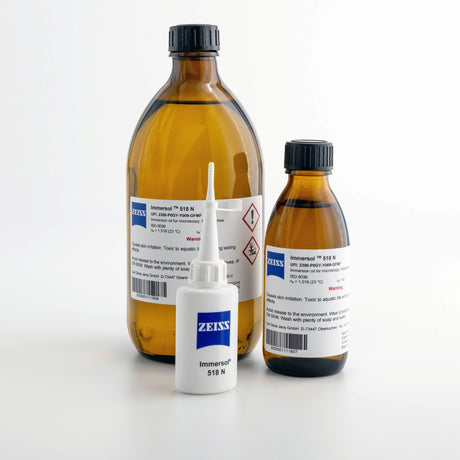 ZEISS Immersol 518 N Immersionsöl in zwei Braunglasflaschen und einem weißen 20 ml Dosierer für die Mikroskopie.